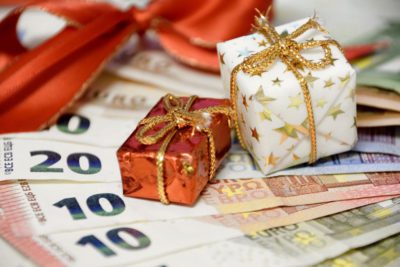 Imagem ilustrativa de notas de dinheiro com enfeites de natal.